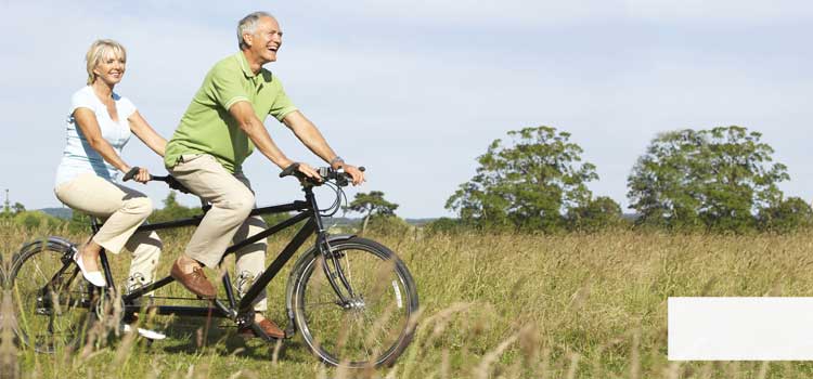 Vea una mujer y un hombre en una bicicleta tándem haciendo una excursión de bicicleta.