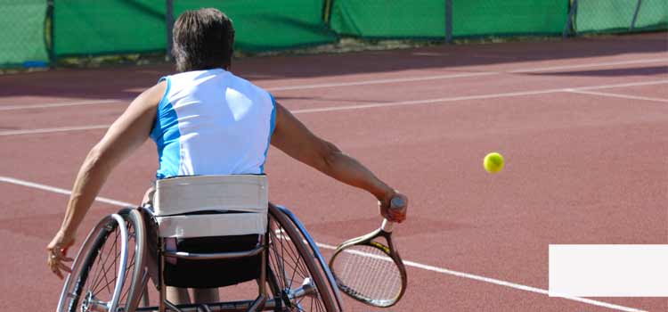 Vea un hombre en silla de ruedas. Está jugando al tenis.